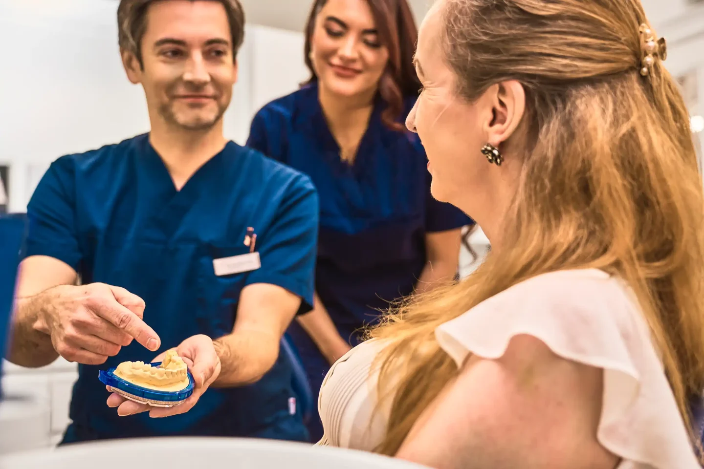 Dr. Jörn Kröger, M. Sc. zahnmedizinische Prothetik, zeigt einer Patientin einen Zahnabdruck
